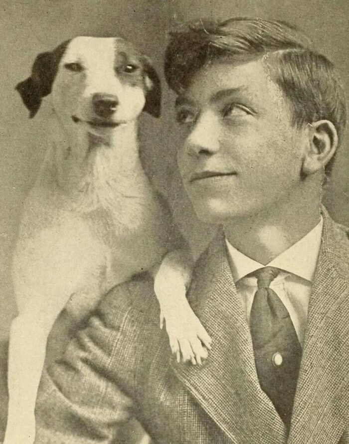 A classic vintage portrait of a smiling young man with his dog, captured in old photos of animals