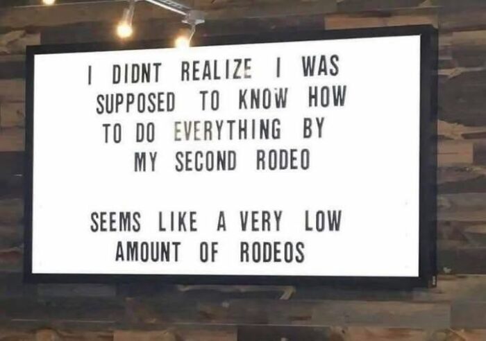 A funny sign reading, I DIDNT REALIZE I WAS SUPPOSED TO KNOW HOW TO DO EVERYTHING BY MY SECOND RODEO. Seems like a very low amount of rodeos.