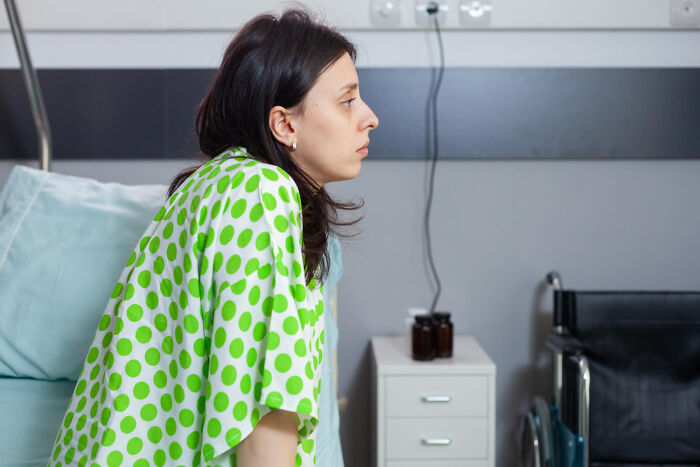 A worried patient in a hospital gown, reflecting on unusual medical practices