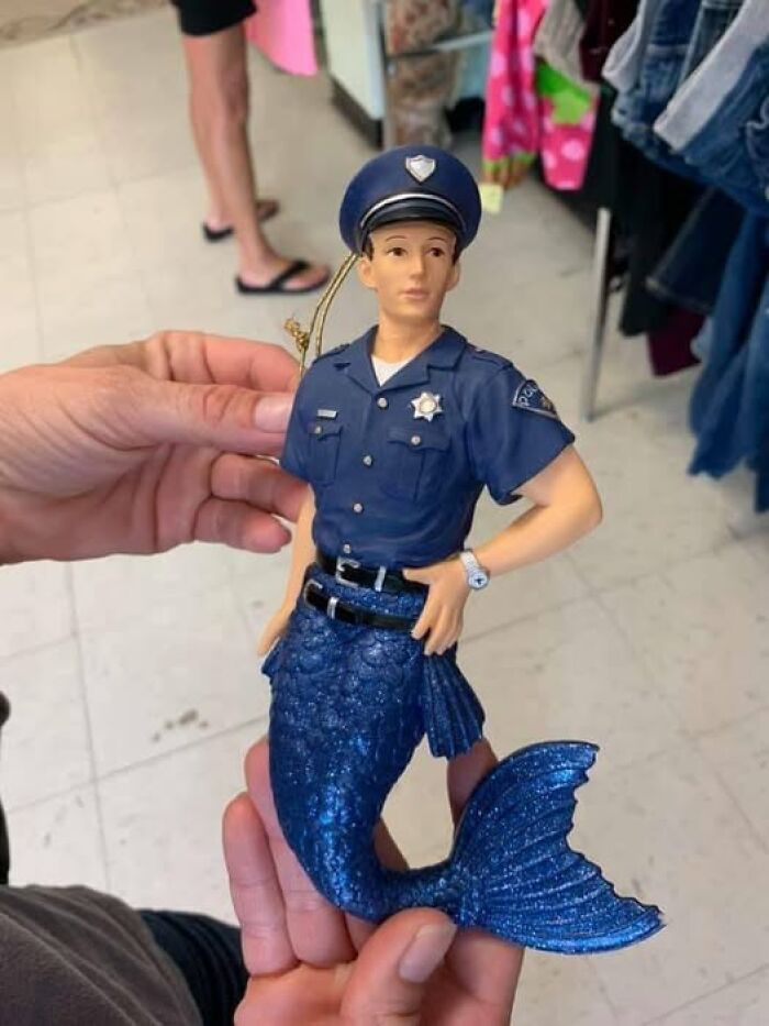 An unhinged secondhand find: a mermaid figurine dressed in a police officer's uniform.