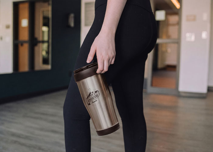 A person holding a coffee cup, central to an honors student's school suspension and new rule challenge.