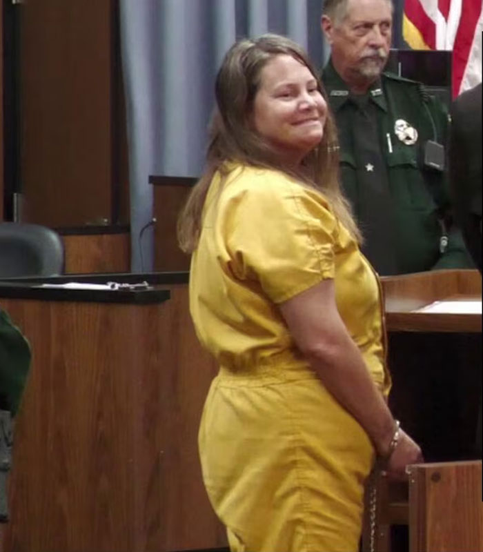 Woman in yellow jumpsuit smiles during trial where the children's mother is identified as the attacker. Woman in yellow jumpsuit smiles during trial where the children's mother is identified as the attacker.