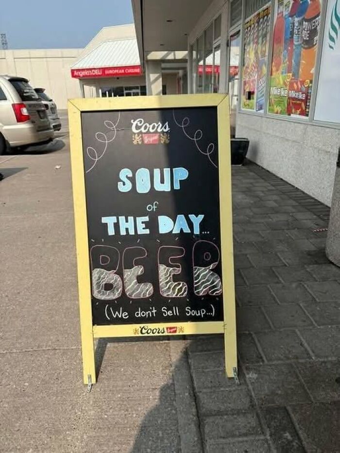 A funny sign outside a store, a yellow chalkboard with SOUPS OF THE DAY... BEER written in colorful chalk.