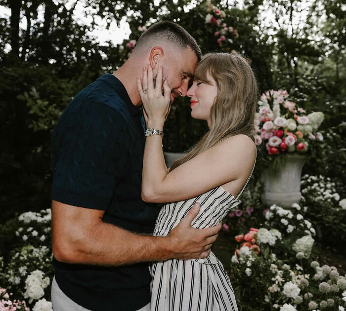 A couple embracing amidst lush floral arrangements, captured in a fan's final video moment. A couple embracing amidst lush floral arrangements, captured in a fan's final video moment.