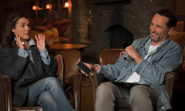 An Emmy Winner with his wife, looking happy during a tense moment, with a body language expert present.