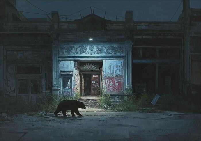 A bear walks past a run-down urban storefront at night in dystopian paintings by Kevin Peterson.