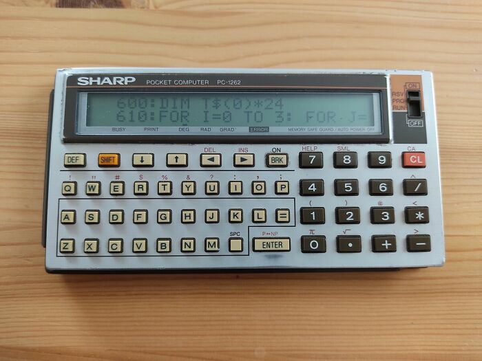 A Sharp PC-1262 pocket computer, an example of retro tech from the '80s, displaying code on its screen.