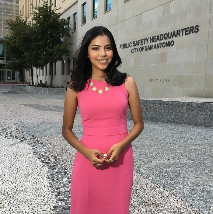A female lawyer in a bright pink dress smiling, addressing the inappropriate dress debate