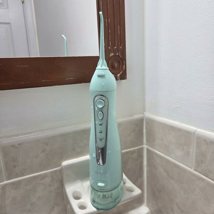 A light blue cordless water flosser on a bathroom shelf, featured in Prime Big Deal Days picks