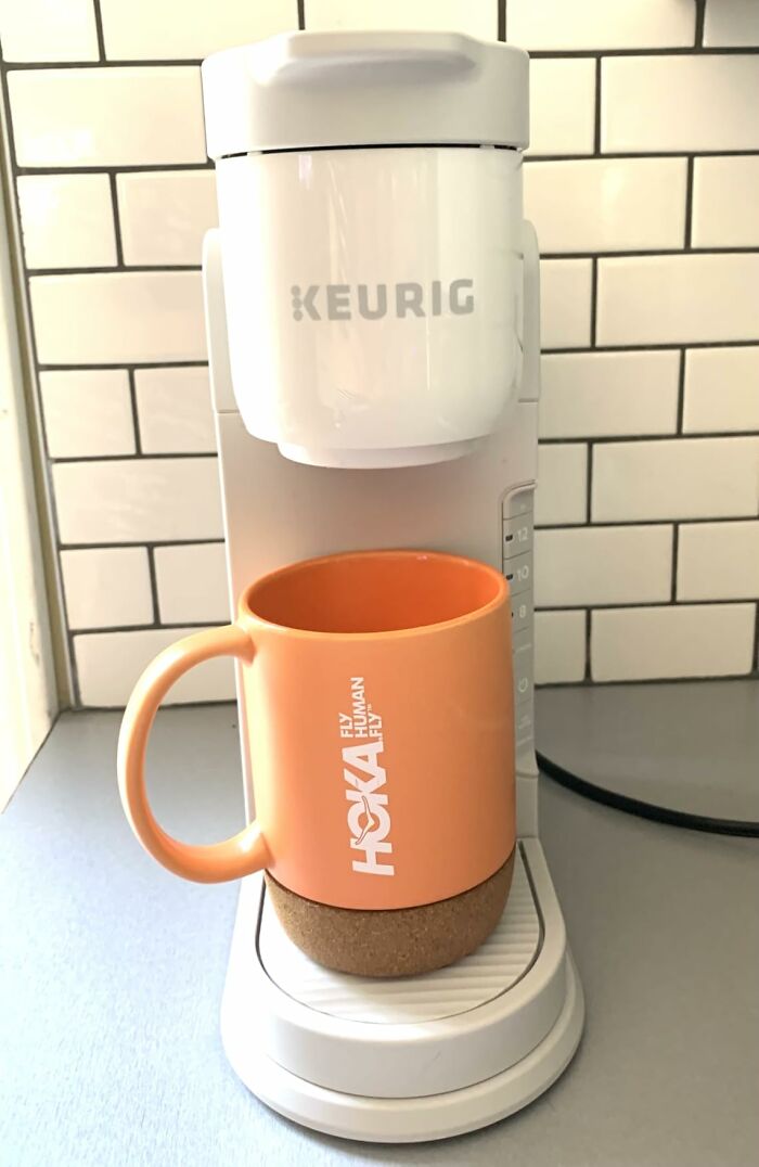 An orange Hoka mug sits under a white Keurig coffee maker, a Prime Big Deal Days favorite