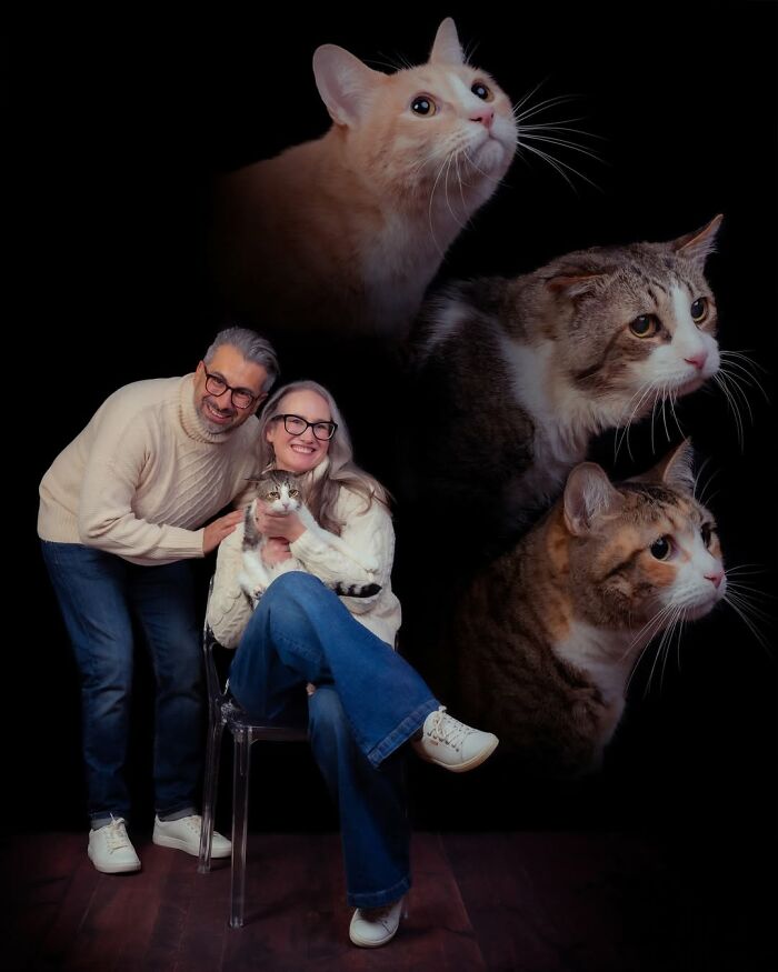 A happy couple poses with their small cat, with two additional cat portraits floating above them. This silly and quirky image captures pets and their owners.