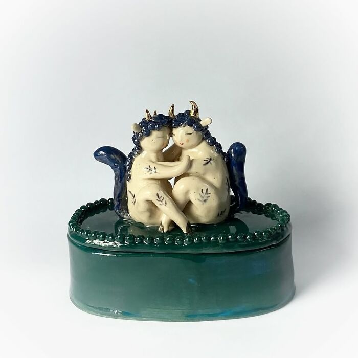 Blue and white ceramic sculptures of a cuddling horned couple, perfect for home decor