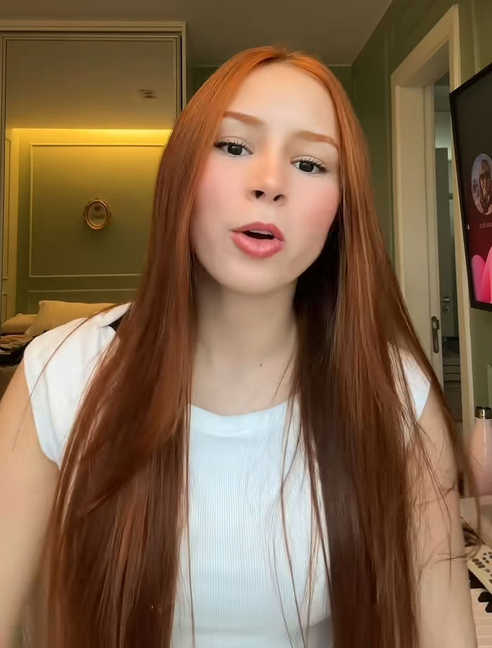 Redheaded influencer talking to the camera about her recent surgery