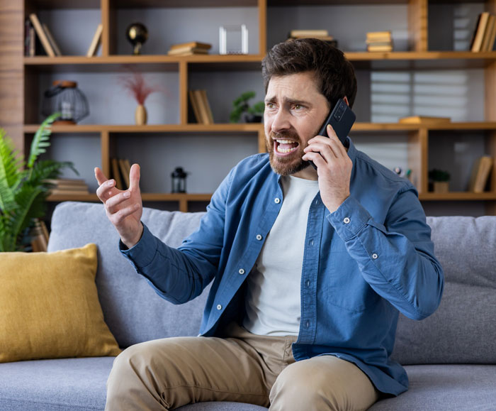 An angry man on a phone call, frustrated with his family over babysitting expectations. An angry man on a phone call, frustrated with his family over babysitting expectations.