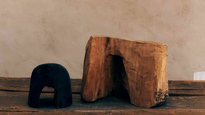 Heather Chontos creative art piece: a small dark sculpture and a larger, carved wooden block.