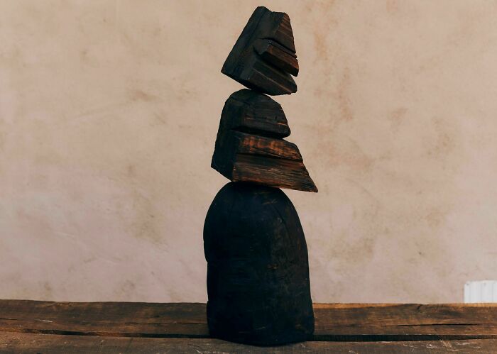 Heather Chontos creative art sculpture featuring dark, stacked, abstract wooden shapes.
