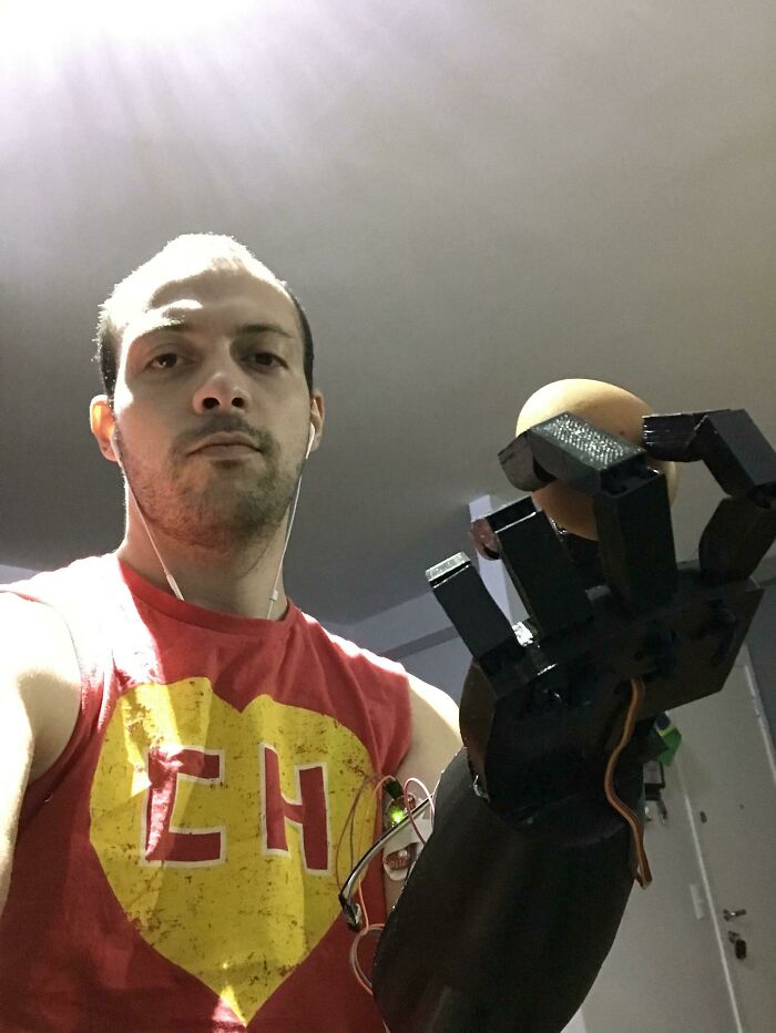 A man holding a black 3D printed prosthetic hand, displaying brilliant creations from 3D printers.