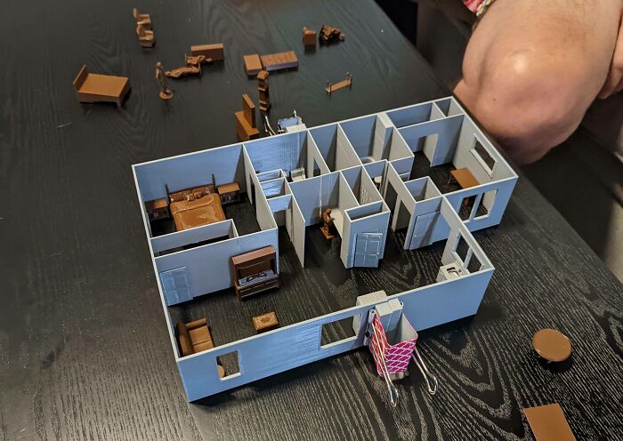 A miniature 3D printed house model with tiny furniture, demonstrating brilliant uses of 3D printers.