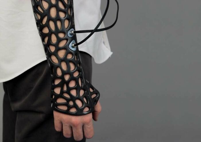 A custom 3D printed prosthetic arm with an intricate black design, showcasing brilliant 3D printing.