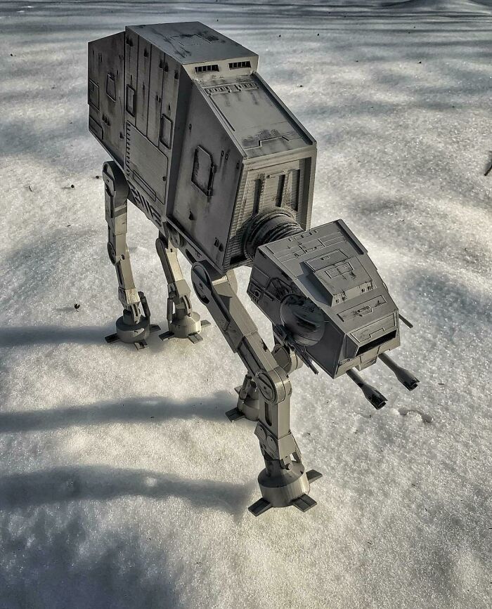 A detailed 3D printed model of an AT-AT walker from Star Wars standing on a snowy surface.