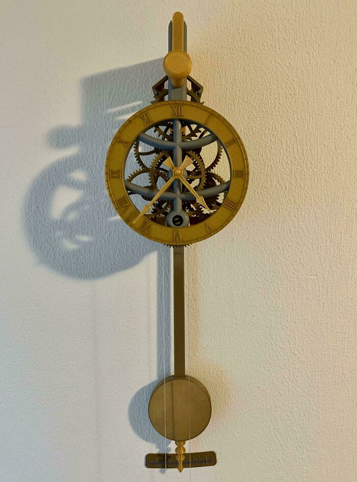 An intricate pendulum clock with visible gears, a brilliant item made with 3D printers.