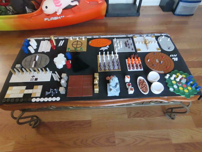 Table full of diverse 3D printed game pieces and boards, brilliant creations from 3D printers.