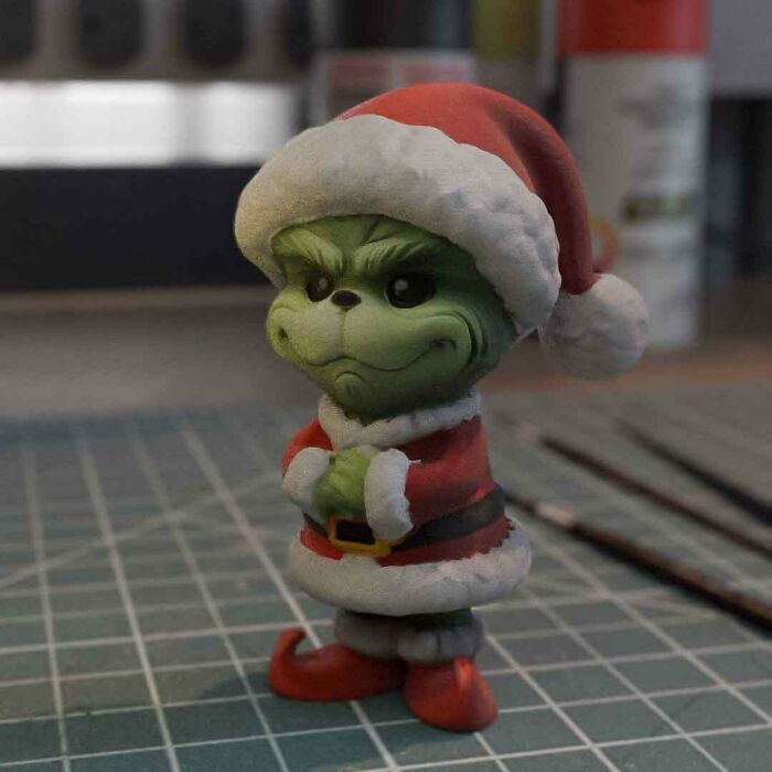 A detailed Grinch figurine wearing a Santa suit, an example of brilliant stuff made with 3D printers.