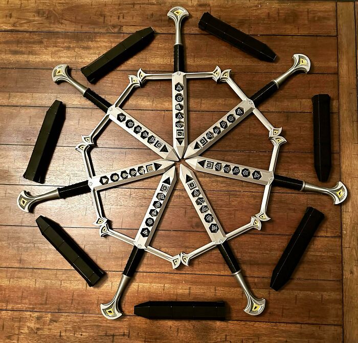 Nine 3D printed swords with decorative handles and blades arranged in a circle, brilliant stuff.