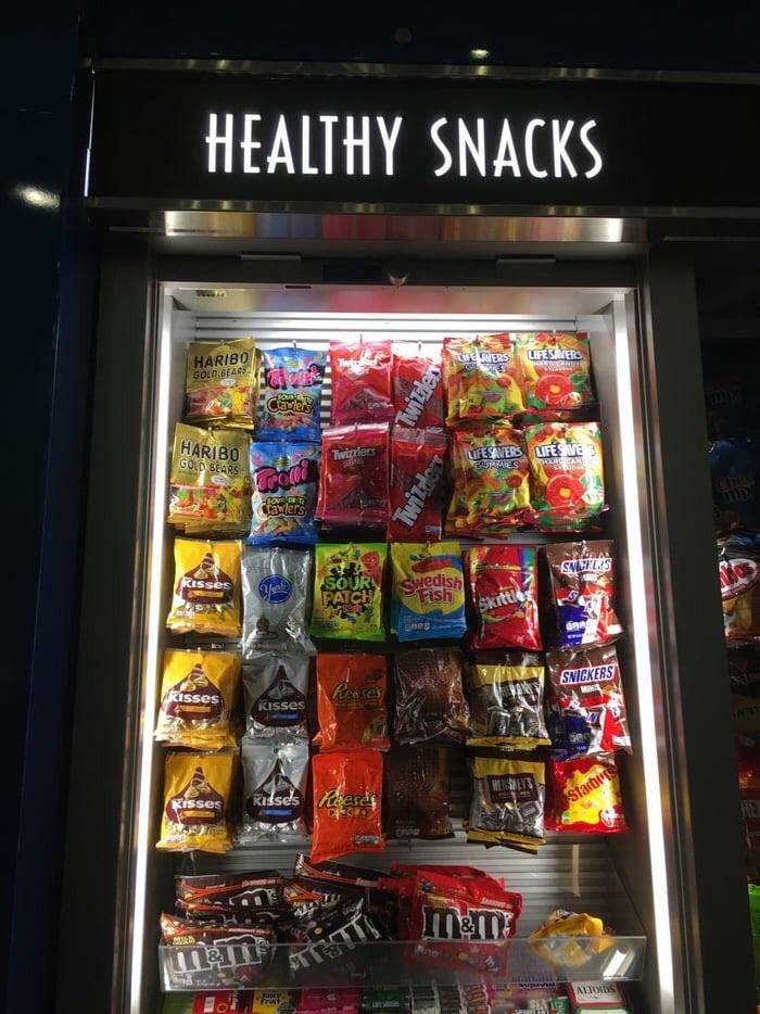 Hilarious and weird things spotted at airports: a vending machine labeled HEALTHY SNACKS filled only with candy and chocolate.
