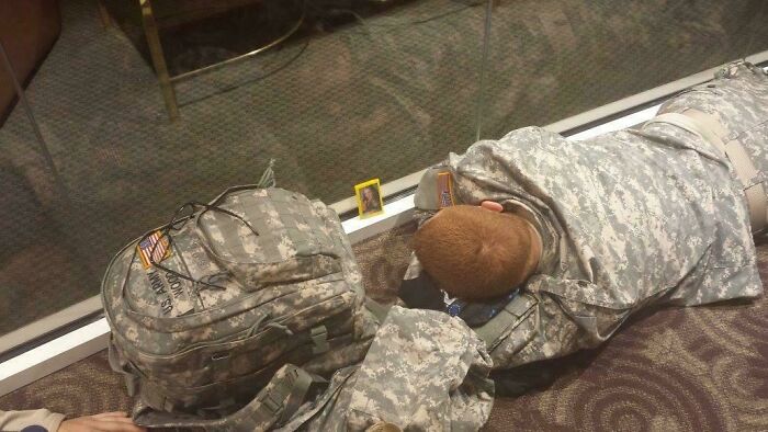 A soldier sleeping on the floor next to his backpack, one of the weird things spotted at airports.