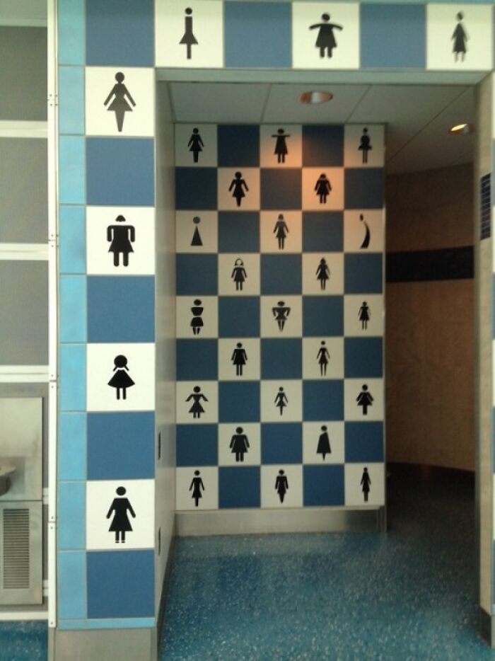 A bizarrely tiled bathroom entrance with various female figures, one of the weird things spotted at airports.