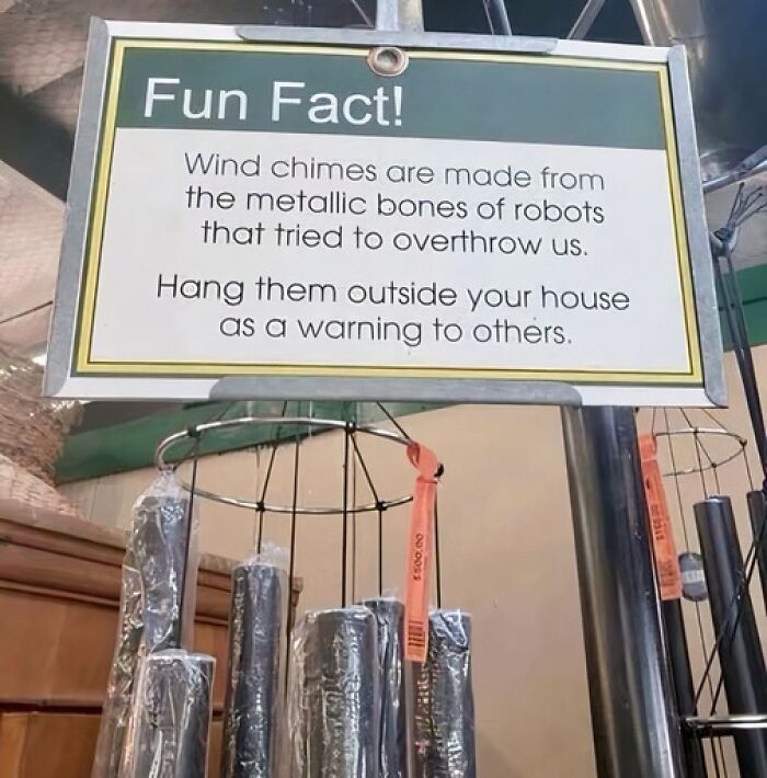 A funny sign with a fun fact about wind chimes being made from metallic robot bones to warn others.