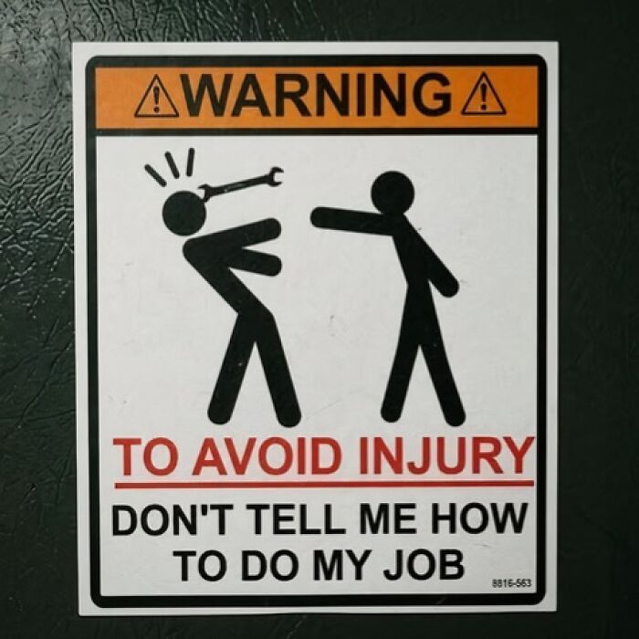 A silly-funny-sign with stick figures. One is hitting the other with a wrench and the text says, Dont tell me how to do my job.