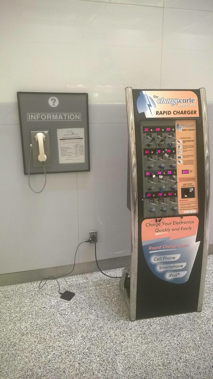 An old payphone next to a modern rapid charger, an unusual juxtaposition among things spotted at airports.