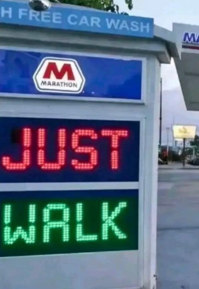 A silly funny sign at a car wash humorously says JUST WALK where it should say WASH.