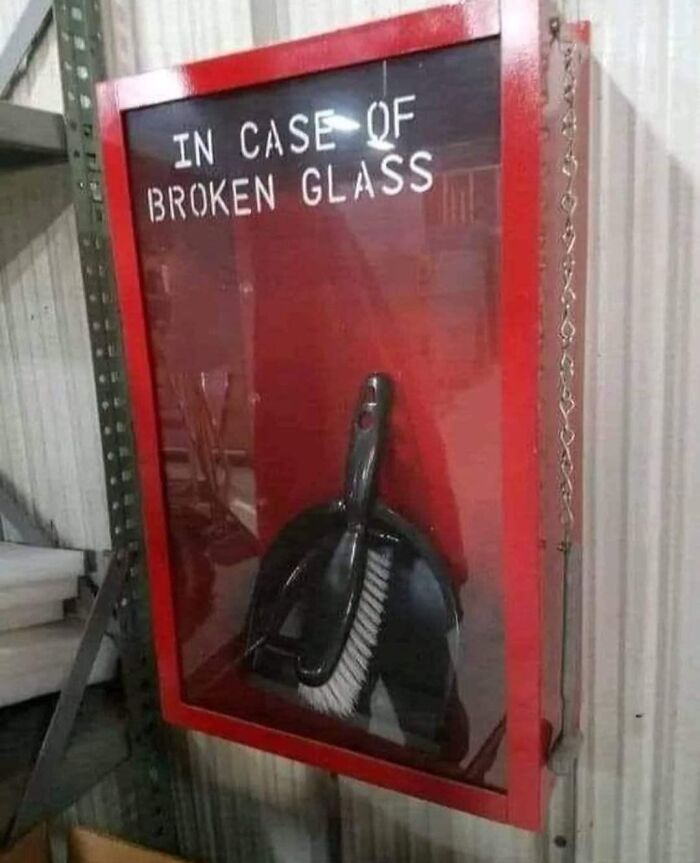 A silly funny sign for a broom and dustpan set inside a glass case reads In Case of Broken Glass.