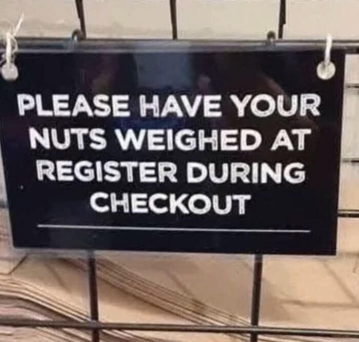 A funny sign reading Please have your nuts weighed at register during checkout, a silly sign in a store.