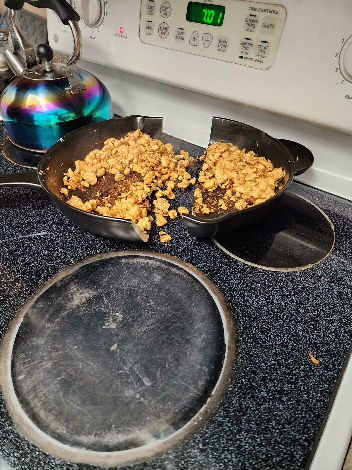 A cast iron pan with food split in two on a stove, illustrating a significant kitchen fail.