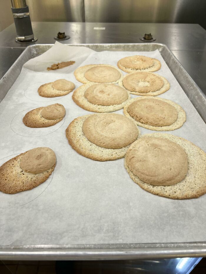 A baking sheet with several misshapen, collapsed baked goods, a perfect example of kitchen fails.