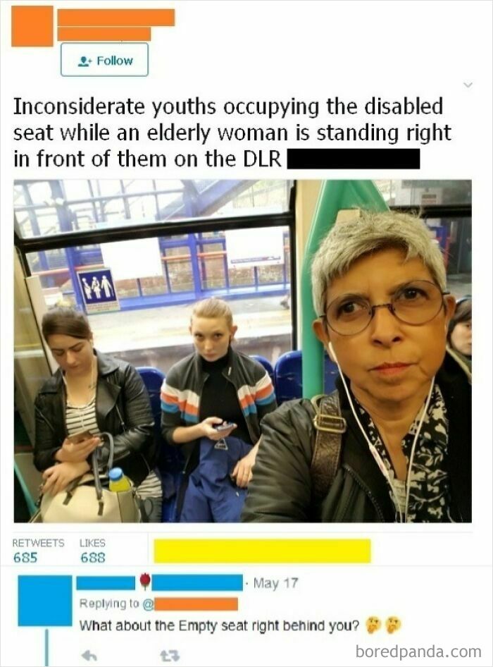 Image showing inconsiderate youths occupying a disabled seat on the DLR while an elderly woman stands, an example of unbelievably stupid behavior.