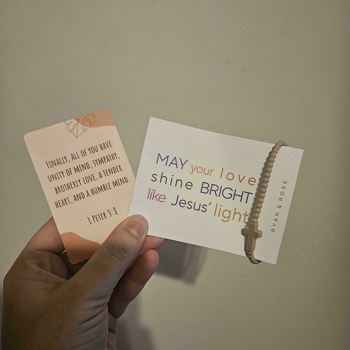Hand holding two cards with religious messages, like many unhinged Vinted posts seen online.