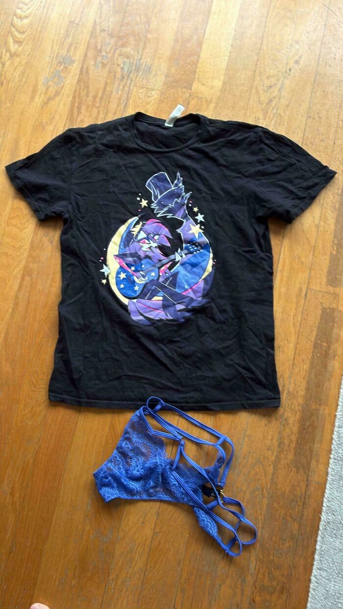 An unhinged Vinted post displaying a black graphic t-shirt and blue lace underwear on a wooden floor.