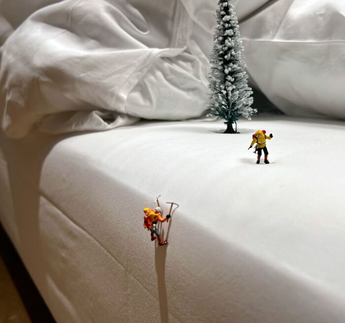 Miniature Calendar work by Tatsuya Tanaka showing tiny climbers scaling a white bedsheet mountain.