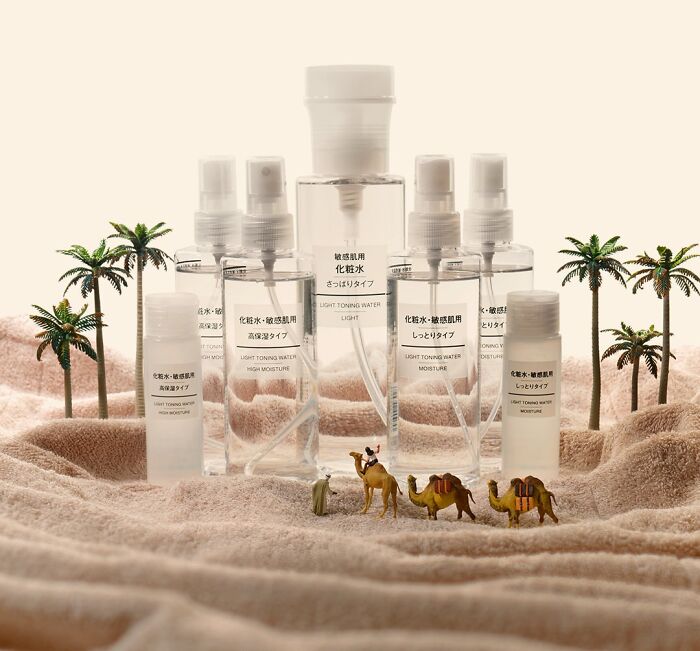A miniature calendar work by Tatsuya Tanaka, showcasing miniature camels and people in a desert of skincare bottles.