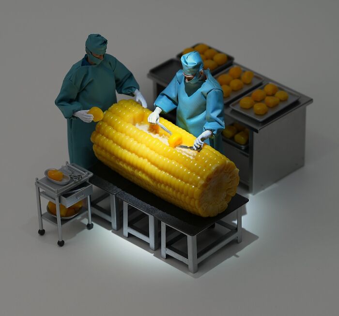 Miniature calendar works by Tatsuya Tanaka: Surgeons operating on a giant ear of corn with tiny tools.