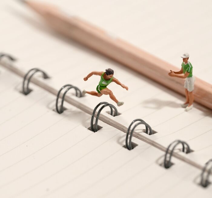 Miniature Calendar work by Tatsuya Tanaka: miniature athlete jumping hurdles made from a notebook's rings.