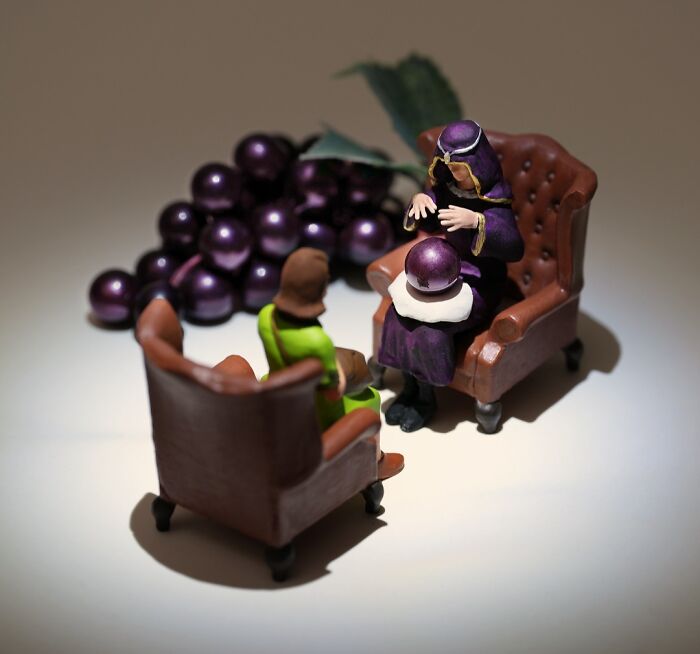 A miniature calendar work by Tatsuya Tanaka showing two figures seated, talking with grapes in the background.