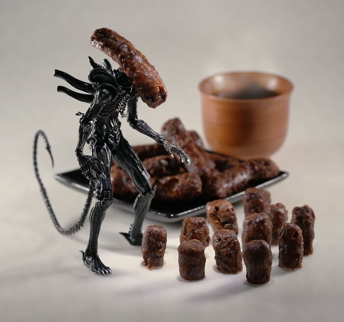 Tatsuya Tanaka miniature calendar work: An Alien figure with a sausage head stands among small sausage pieces.