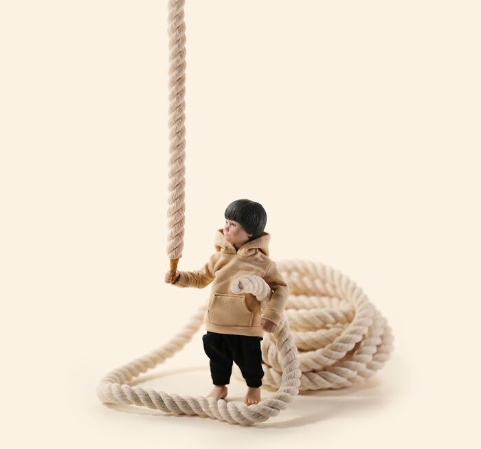 Miniature calendar scene by Tatsuya Tanaka of a small figure holding a large rope.