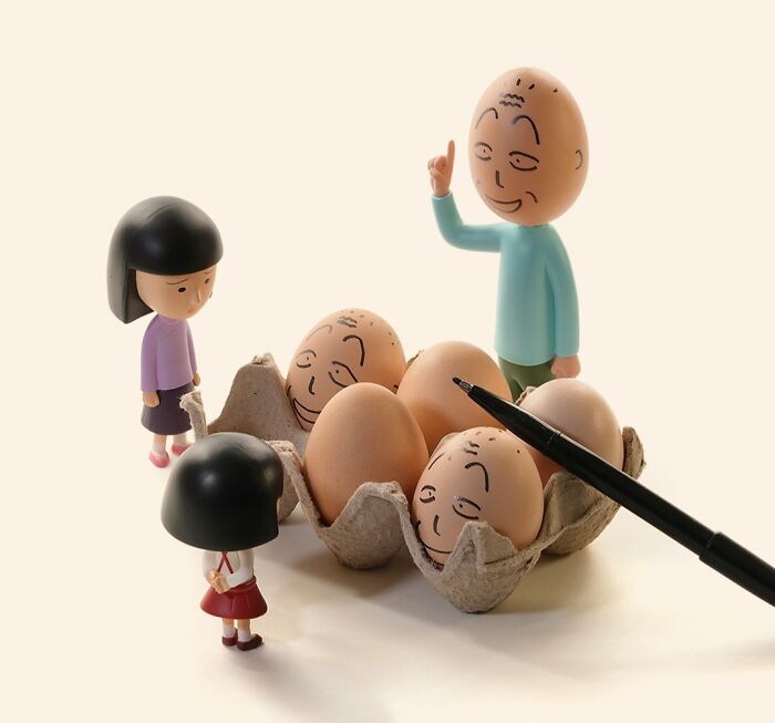 Miniature calendar works by Tatsuya Tanaka: two small figures and eggs with faces drawn on them in a carton.